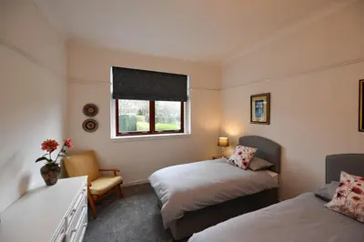 a bedroom with two beds and a window at Dunvegan Apartment Troon in Troon