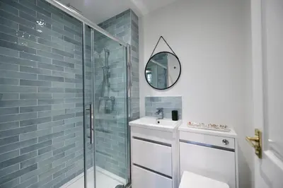 a bathroom with a shower and a sink and a mirror at Dunvegan Apartment Troon in Troon