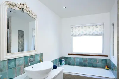 a bathroom with a sink and a tub and a mirror at The Well in Mainsriddle
