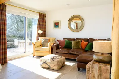a living room with a couch and a chair at The Well in Mainsriddle