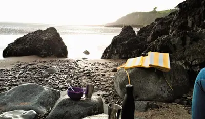 a book sitting on a rock on the beach at The Well in Mainsriddle