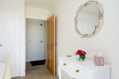 a white room with a mirror and a white dresser at The Well in Mainsriddle
