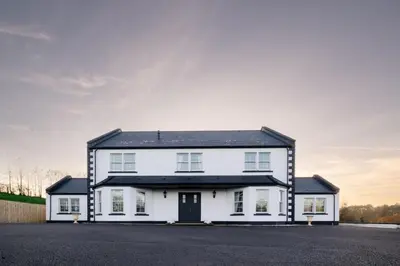 a white house with a black roof at Coylebrae House in Ayr