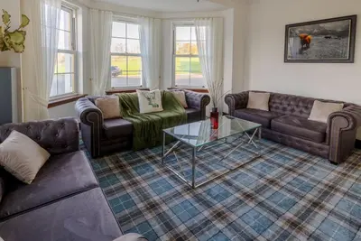 a living room with couches and a glass table at Coylebrae House in Ayr