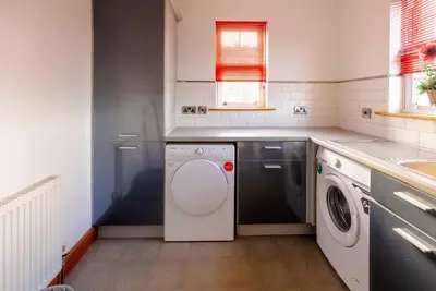 a kitchen with a washing machine and a sink at Coylebrae House in Ayr