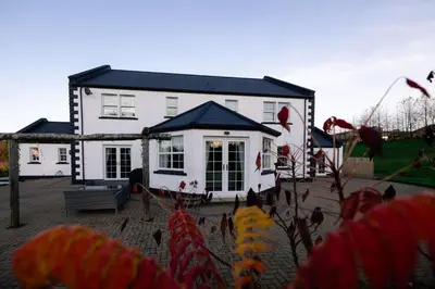 a white house with a black roof at Coylebrae House in Ayr