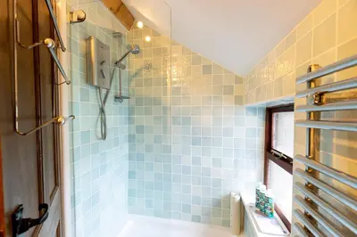 a bathroom with a shower with blue tiles at HIGH TREES BYRE - Two bed Cottage with Log Burner & Incredible Views in Workington