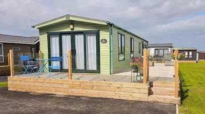 a green tiny house on a wooden deck at Foxgloves and Ivy in Cockermouth