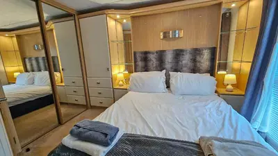 a bedroom with a large white bed and mirrors at Foxgloves and Ivy in Cockermouth