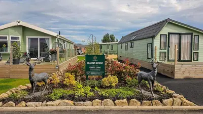 two deer statues in a garden in front of a house at Foxgloves and Ivy in Cockermouth