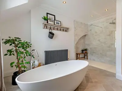 a white bath tub in a bathroom with a plant at 6 Bed in Keswick 94361 in Keswick