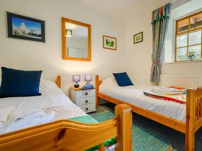 a bedroom with two beds and a mirror at 3 Bed in Watermillock SZ318 in Watermillock