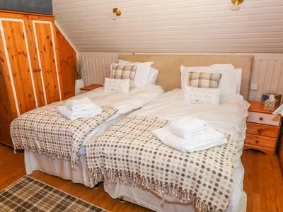 a bedroom with a bed with towels on it at Thistle Dubh 