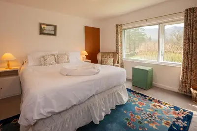 a bedroom with a large bed with a large window at Beckfoot Chapel Stile - Ambleside in Chapel Stile