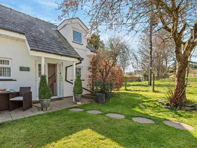 a house with a yard with a table and chairs at 1 Bed in Bassenthwaite 91211 in Bassenthwaite Lake