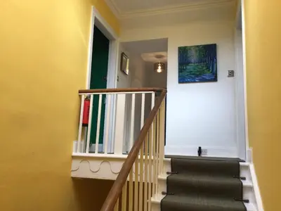 a staircase in a house with a painting on the wall at Mansefield Rooms in Lockerbie
