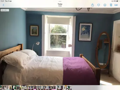a bedroom with a bed and a window and a mirror at Mansefield Rooms in Lockerbie