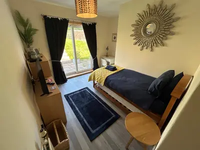 a bedroom with a bed and a mirror on the wall at Ladyland Cottage in Maybole in Maybole