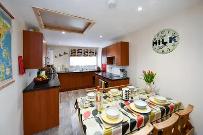 a kitchen with a table and chairs in a room at Ladyland Cottage in Maybole in Maybole