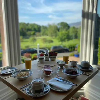 a table with food on it with a window at Burleigh Mead in Keswick