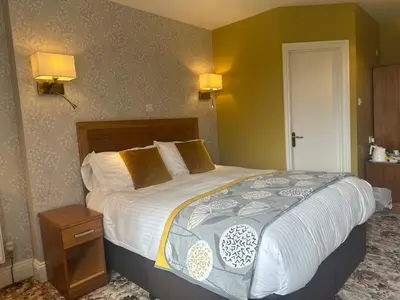 a large bed in a hotel room with two lamps at Burleigh Mead in Keswick