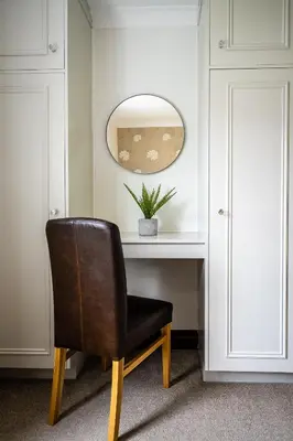 a chair sitting in front of a desk with a mirror at Acorn Apartment 2 (upper) in Keswick