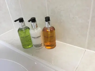 three bottles of soap andodorizers sitting on a sink at Acorn Apartment 2 (upper) in Keswick