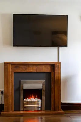 a fireplace with a television on top of it at Acorn Apartment 2 (upper) in Keswick