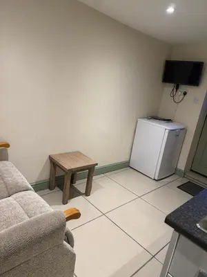 a living room with a couch and a small refrigerator at Doddick Bothy in Threlkeld