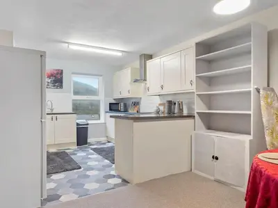 a kitchen with white cabinets and a counter top at Miterdale A Wonderful Home in the Idyllic Duddon Valley in Broughton in Furness