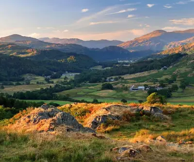 a view of a field with mountains in the background at Miterdale A Wonderful Home in the Idyllic Duddon Valley in Broughton in Furness