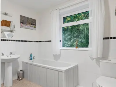 a white bathroom with a tub and a sink and a window at Miterdale A Wonderful Home in the Idyllic Duddon Valley in Broughton in Furness