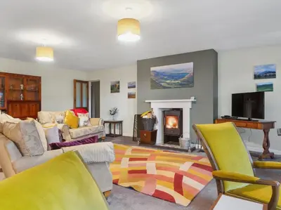 a living room with a couch and a fireplace at Miterdale A Wonderful Home in the Idyllic Duddon Valley in Broughton in Furness