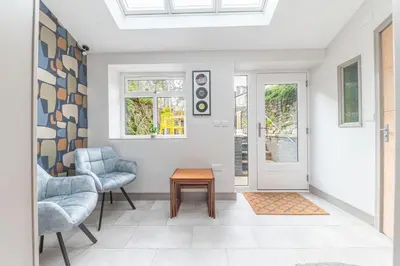 a living room with two chairs and a table at Blue Sky Cottage in Keswick