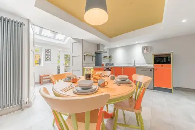 a kitchen and dining room with a wooden table and chairs at Blue Sky Cottage in Keswick