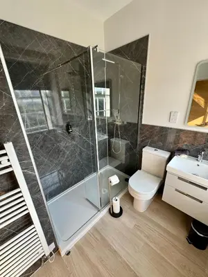 a bathroom with a shower and a toilet and a sink at Grindal Studio Apartments - Newly Opened Luxury Accommodation in St Bees