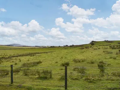 a field with a fence in the middle of a field at Beaumont Lodge in Plumbland