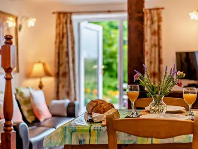 a table with a plate of bread and two glasses of wine at 1 Bed in Eskdale 94530 in Eskdale