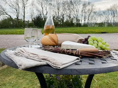 a table with a bottle of wine and some grapes at Pippa's Cottage - Uk42332 in Little Blencow