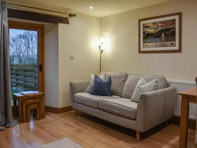 a living room with a couch and a window at Pippa's Cottage - Uk42332 in Little Blencow