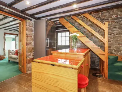 a kitchen with a spiral staircase in a brick wall at The Gardener's Bothy in Penrith