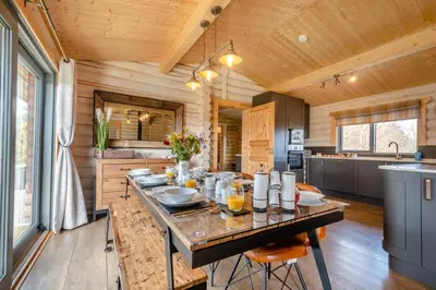 a large kitchen with a table in a log cabin at 3 Bed in Colvend oc-t28900 in Kippford
