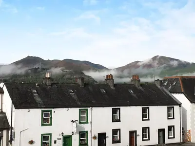 a white house with mountains in the background at Grisedale View - Hewetson Court in Keswick
