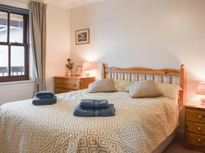 a bedroom with a bed with two blue towels on it at Grisedale View - Hewetson Court in Keswick