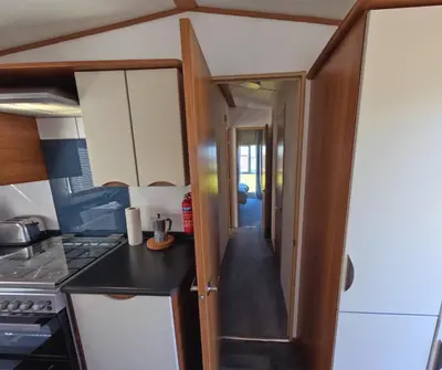 a small kitchen with a counter and a hallway at Woodside, Meadows Retreat, Cockermouth in Plumbland