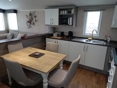 a small kitchen with a wooden table and chairs at Green Dream in Cockermouth