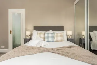 a bedroom with a large white bed with two lamps at South Beach View in Troon