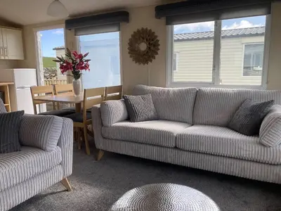 a living room with two couches and a table at Beautifully Presented 2 Bedroom Static Caravan in Monreith