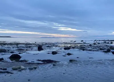 a beach with rocks and water and a cloudy sky at Beautifully Presented 2 Bedroom Static Caravan in Monreith
