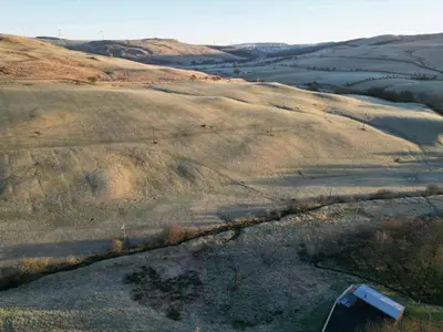 an aerial view of a field with grass and hills at Laigh Letterpin Lodge in Girvan